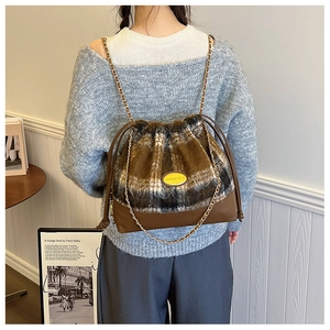 Rear view of a stylish brown plaid drawstring bucket bag with golden chain straps