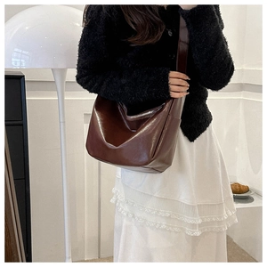 Detail of caramel brown PU leather tote bag showing soft texture and silver zipper closure