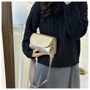 Detail of gold crossbody bag with wide jacquard strap and FASHION & BAGS logo