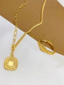 Dettaglio della collana con ciondolo quadrato dorato vintage e anello a catena abbinato