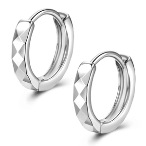 Créoles en argent brillant avec taille diamant et texture géométrique sur fond blanc