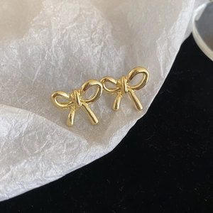 Elegant 3D golden bow stud earrings in polished stainless steel for a minimalist look