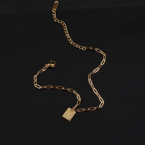 Golden paperclip chain anklet with a polished Good Luck square tag and adjustable clasp