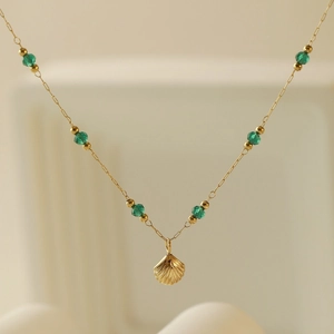Bracelet de cheville doré élégant avec perles émeraude et pendentif coquillage raffiné