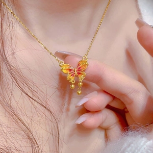 Collier papillon en or raffiné avec ailes en émail orange et pampilles délicates