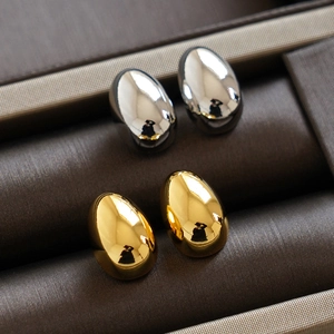Ensemble de boucles d'oreilles boules en or et argent dans un écrin brun foncé