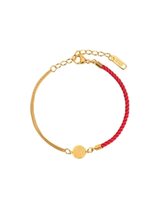 Macro view of gold lucky Fu pendant with 18KGP engraving on adjustable red rope anklet