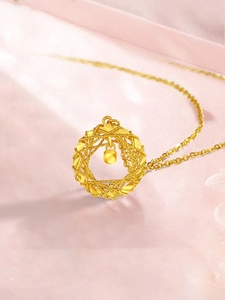 Close-up of golden woven wreath necklace with a central polished cube pendant
