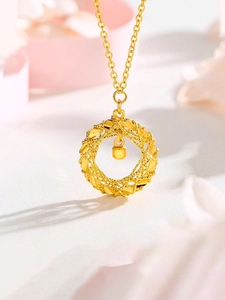Macro shot of gold dreamcatcher pendant with mobius cube charm and delicate o-chain link