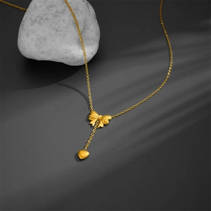 Elegant gold titanium steel necklace featuring a tassel bow and heart pendant