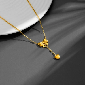 Golden titanium steel necklace with matte bow and polished heart tassel pendant