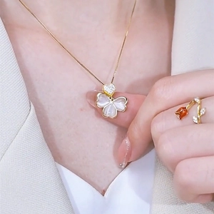 Elegant gold necklace with clover opal pendant and matching rose ring on model