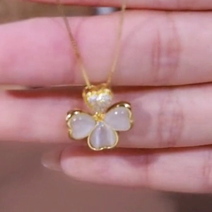 Golden clover necklace with heart-shaped crystal pendant and white opal petals