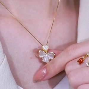 Elegant gold clover necklace with purple opal petals and heart-shaped diamond-set clasp