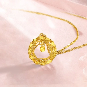 Elegant gold woven circle pendant necklace with a small dangling bead on a silk background