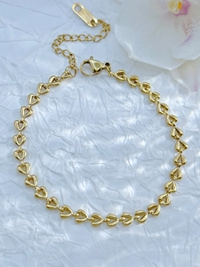 Detail of gold heart-link chain bracelet with lobster clasp and extension chain on white background