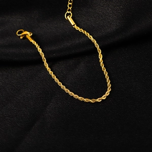 Bracelet chaîne torsadée dorée avec fermoir mousqueton sur fond texturé sombre