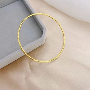 Sparkling 18K gold plated stainless steel bangle with a delicate diamond-cut texture