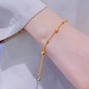 Adjustable 18K gold-plated titanium steel bead bracelet shown on a woman wrist