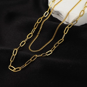 Golden double layer necklace featuring paperclip and curb chain links on black fabric