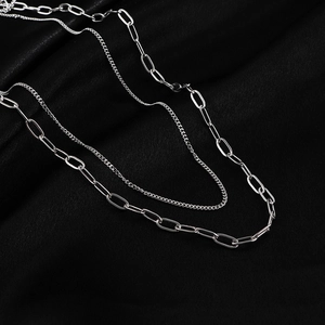 Silver layered paperclip and curb chain necklace set on black silk background