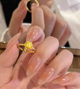 Detail view of a 3D golden rose ring showing exquisite petal layers and slender band