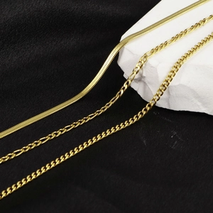 Three-layer layered gold necklaces featuring snake, figaro, and curb chain styles