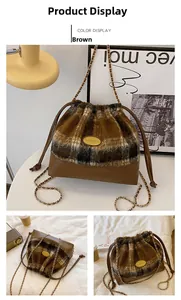 Detail view of brown plaid wool bucket bag with drawstring closure and chain strap