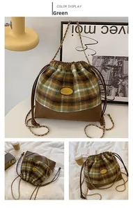 Detail of green plaid wool bucket bag showing leather drawstring and gold chain strap