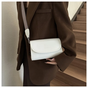 Detail of white leather crossbody bag with wide woven strap and Fashion & Bags text