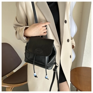 Detail of black mini leather backpack with fashion embossing and beaded drawstring cords