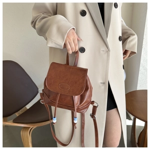 Brown vintage faux leather backpack with fashion embossing and bead drawstring detail