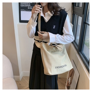Detailansicht der beigefarbenen Canvas-Tasche mit Fashion Bag Text und verstellbarem Gurt