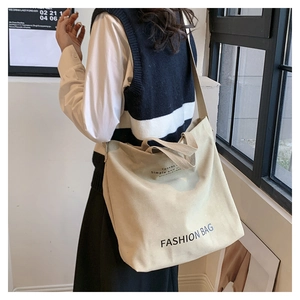 Detaillierte Ansicht der beigen Segeltuch-Tasche mit schwarzem Fashion Bag Aufdruck und Gurt