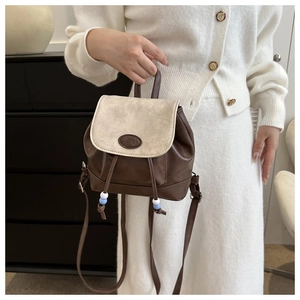 Detail view of contrast color faux leather backpack with drawstring and top handle