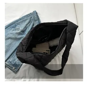 Macro view of black quilted tote bag showing spacious interior with zipper closure