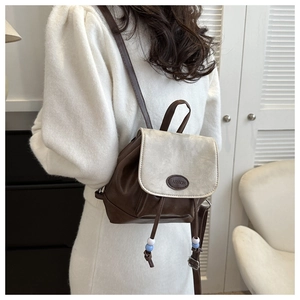 Detail of vintage mini backpack with contrast flap and drawstring on model