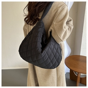 Detailed view of the large quilted rhombus pattern on a black padded hobo bag