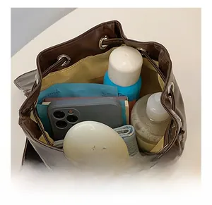 Top view of dark brown bucket bag interior showing large capacity for cosmetics and phone