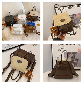 Detail of mini vintage backpack with drawstring closure and cute plush monster pendant