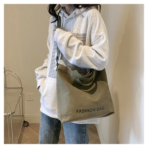 Olivgrüne große Canvas-Einkaufstasche mit schwarzem Fashion Bag Aufdruck am Model