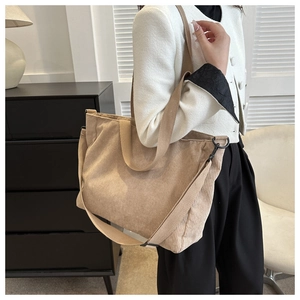 Khaki corduroy tote bag worn by model showing large capacity and adjustable strap