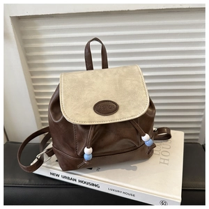 Detail view of mini backpack featuring contrast colors, drawstring and bead accents