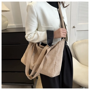 Detail view of beige corduroy tote bag showing soft ribbed texture and detachable strap