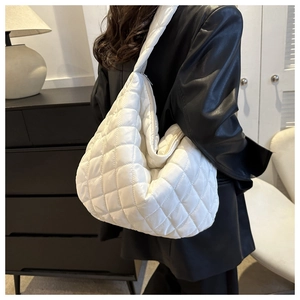 Macro shot of white quilted padded hobo bag showing fluffy texture and premium stitching