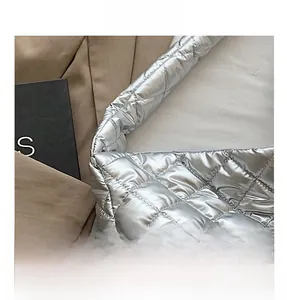 Détail macro d'un sac cabas argenté matelassé avec surpiqûres en losanges et éclat métallique