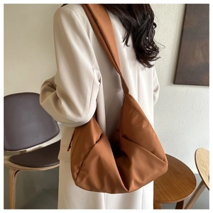 Sac hobo marron caramel porté en bandoulière spacieuse sur un mannequin de mode