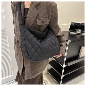 Detail of black quilted puffer crossbody bag showing large capacity and soft nylon texture