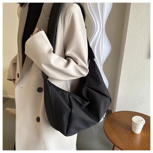 Détail d'un sac à bandoulière en nylon noir en forme de croissant au style matelassé
