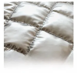 Détail du sac matelassé argenté montrant les coutures et la texture rembourrée